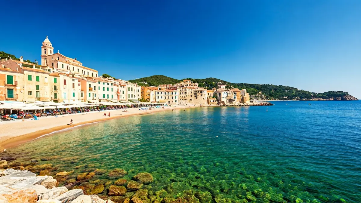 Imatge d'un poble costaner mediterrani amb platja i arquitectura tradicional.