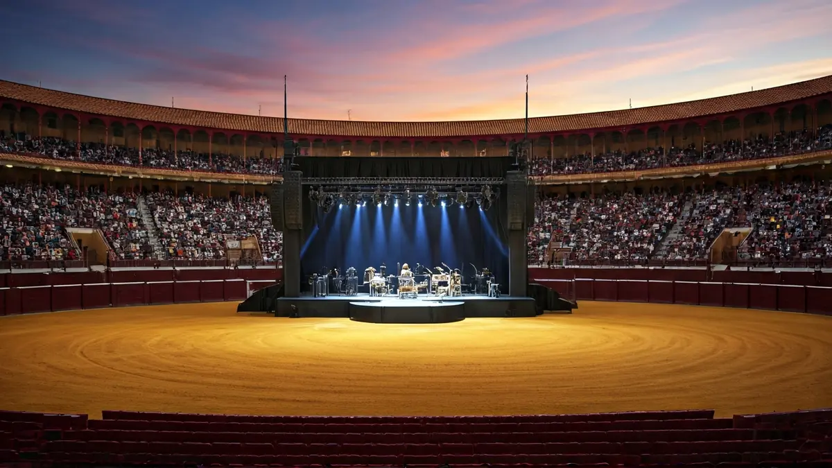 Image of a modern multi-functional space, with a stage for cultural events, dynamic lighting, and a diverse audience, reflecting culture, youth, and inclusion.