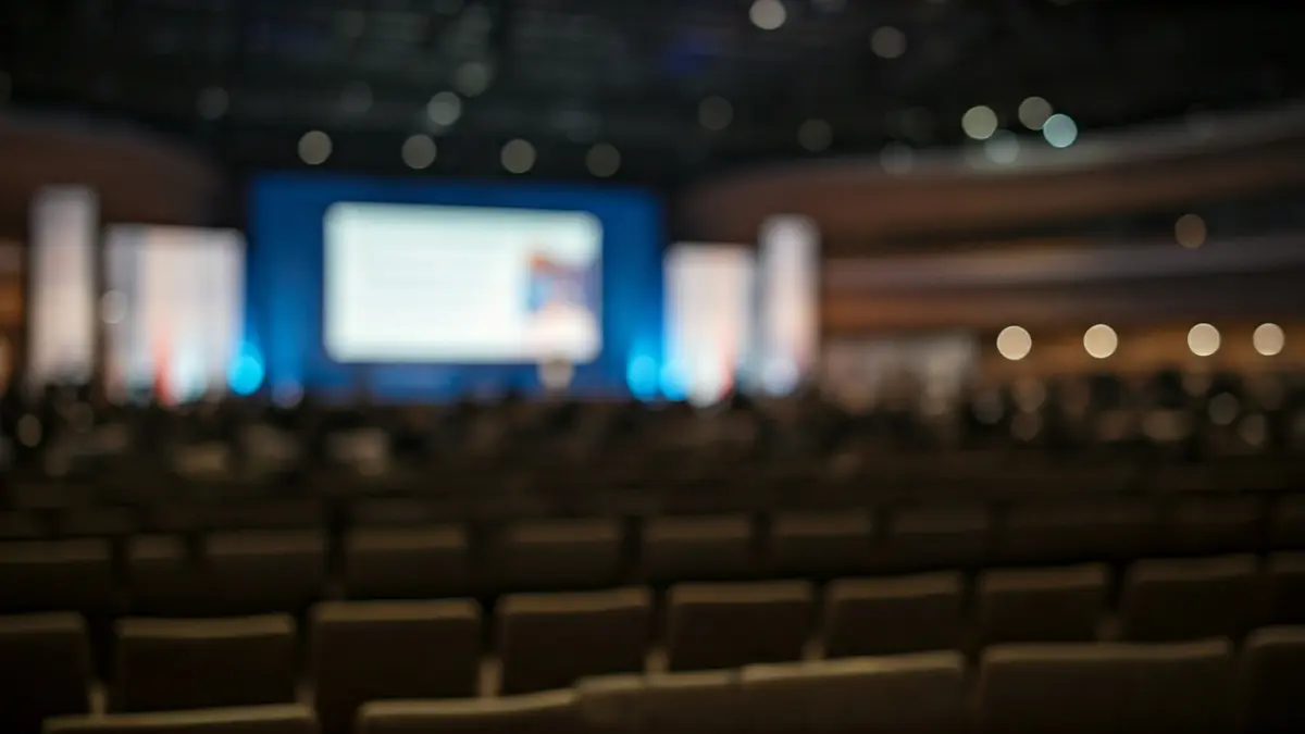 Imatge genèrica d'un fòrum internacional o cimera, amb una sala de conferències buida i una pantalla gran.