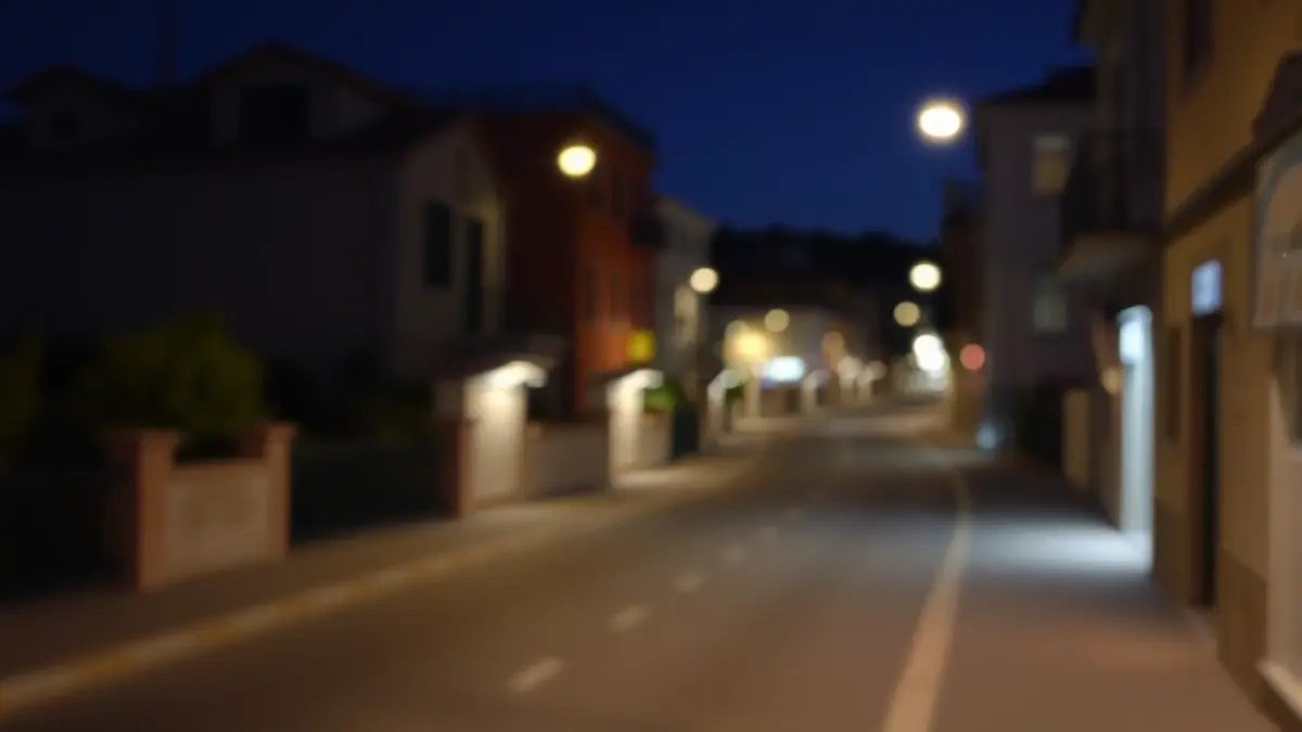 Generic image of an empty street at night in a Mediterranean city, with dim lights.