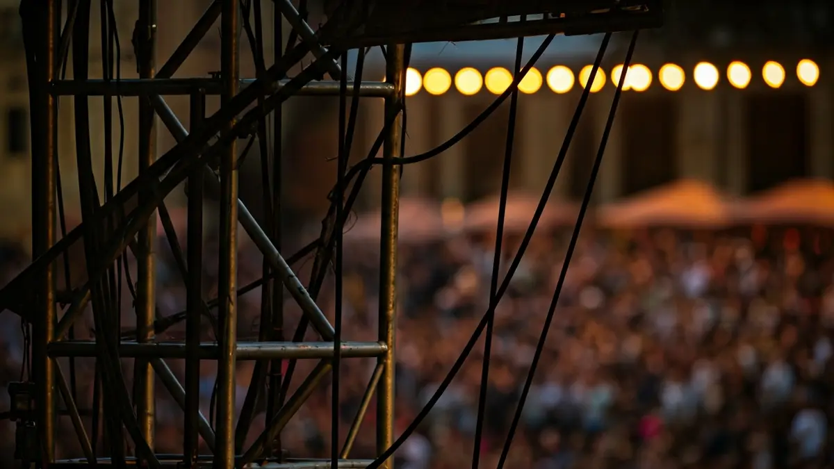 Imatge d'una estructura d'escenari en revisió, amb elements metàl·lics i cables.