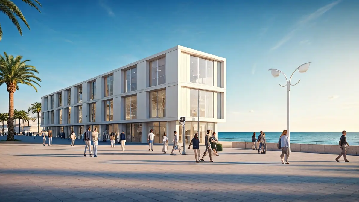 Imatge d'un edifici modular modern en un passeig marítim, amb palmeres i el mar de fons.