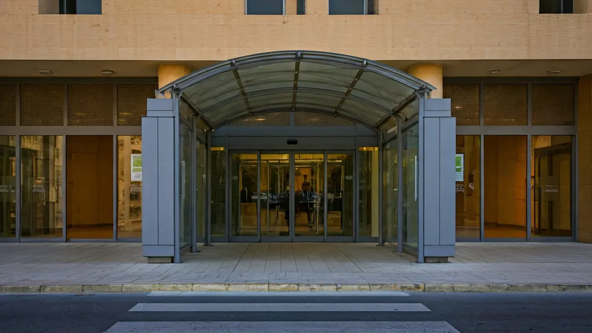 Imagen de un centro de salud con un arco de seguridad en la entrada.