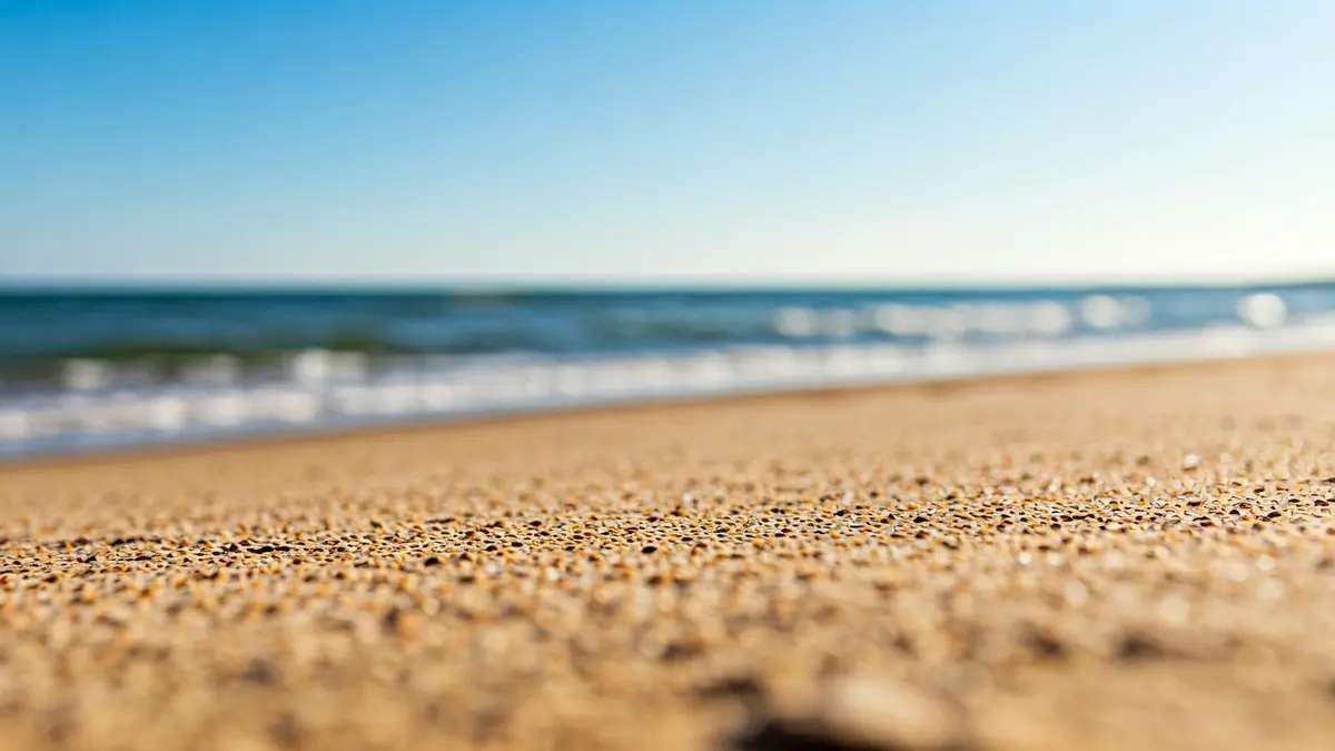 Generic image of a sandy beach with gentle waves, preparing for the summer season.