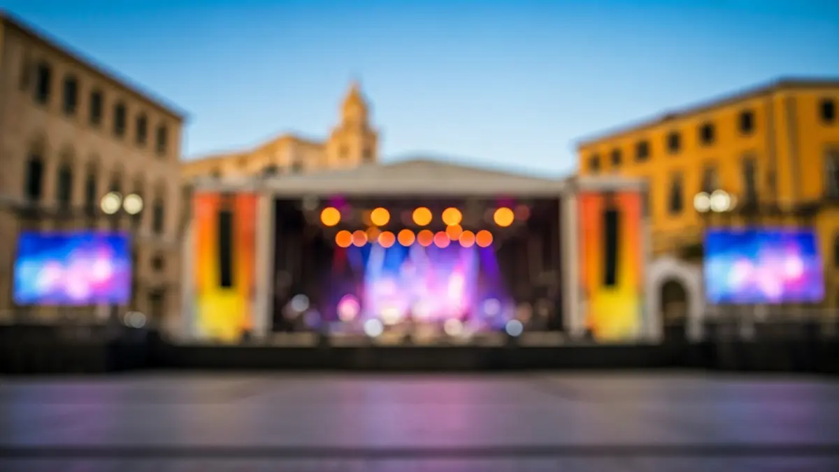 Imatge genèrica d'un escenari de festival de música amb llums i un espai buit, amb arquitectura mediterrània de fons.