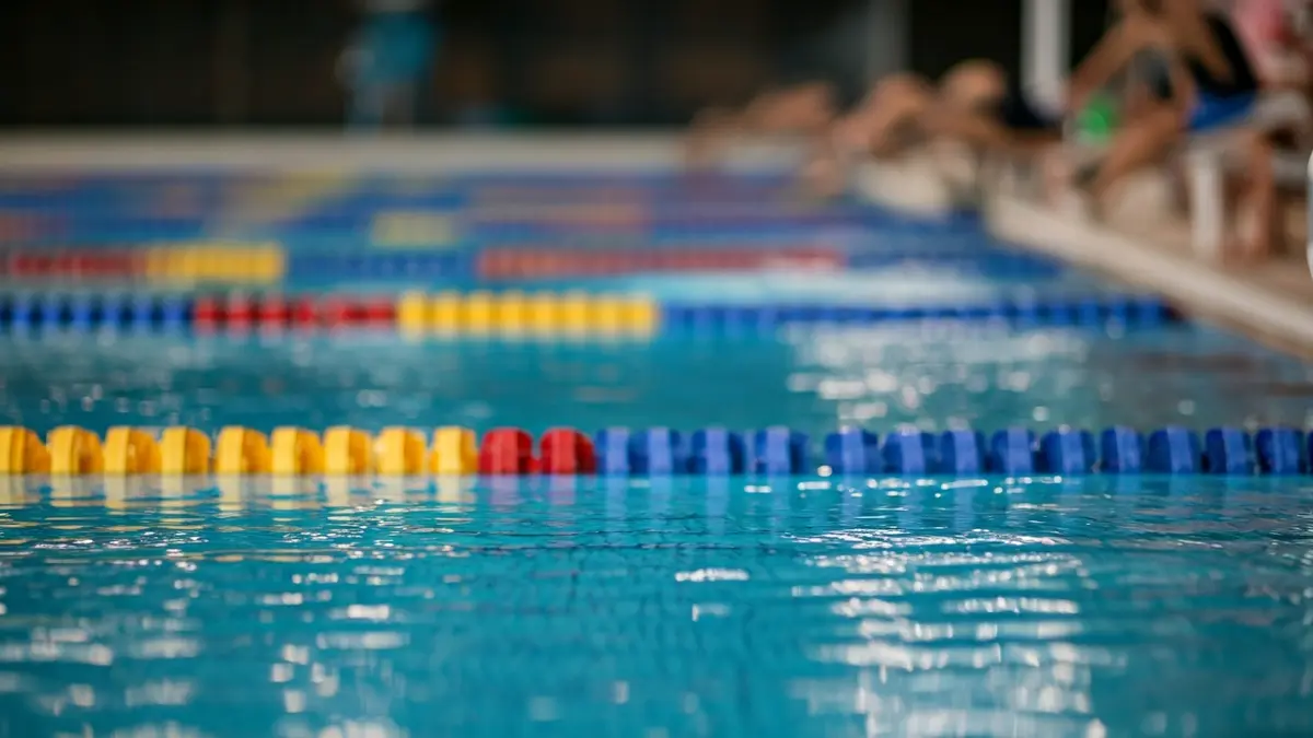 Imatge genèrica d'una piscina coberta amb nadadors joves, representant una competició de natació.