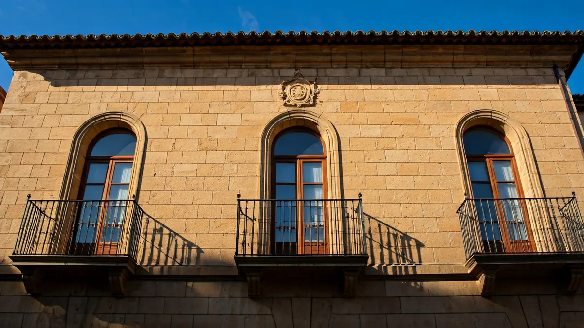 Image of a stone town hall facade with a balcony and iron railings