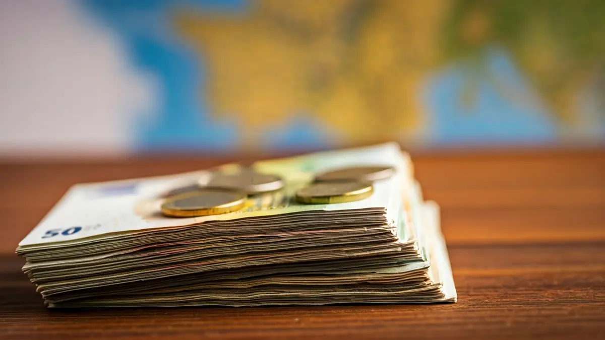 Generic image of cash and a map of the Comunitat Valenciana, symbolizing the economic impact of tourism.
