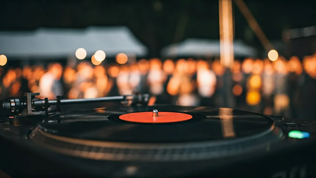 Imatge genèrica d'un disc de vinil girant en un tocadiscos, amb llums d'escenari desenfocades al fons.