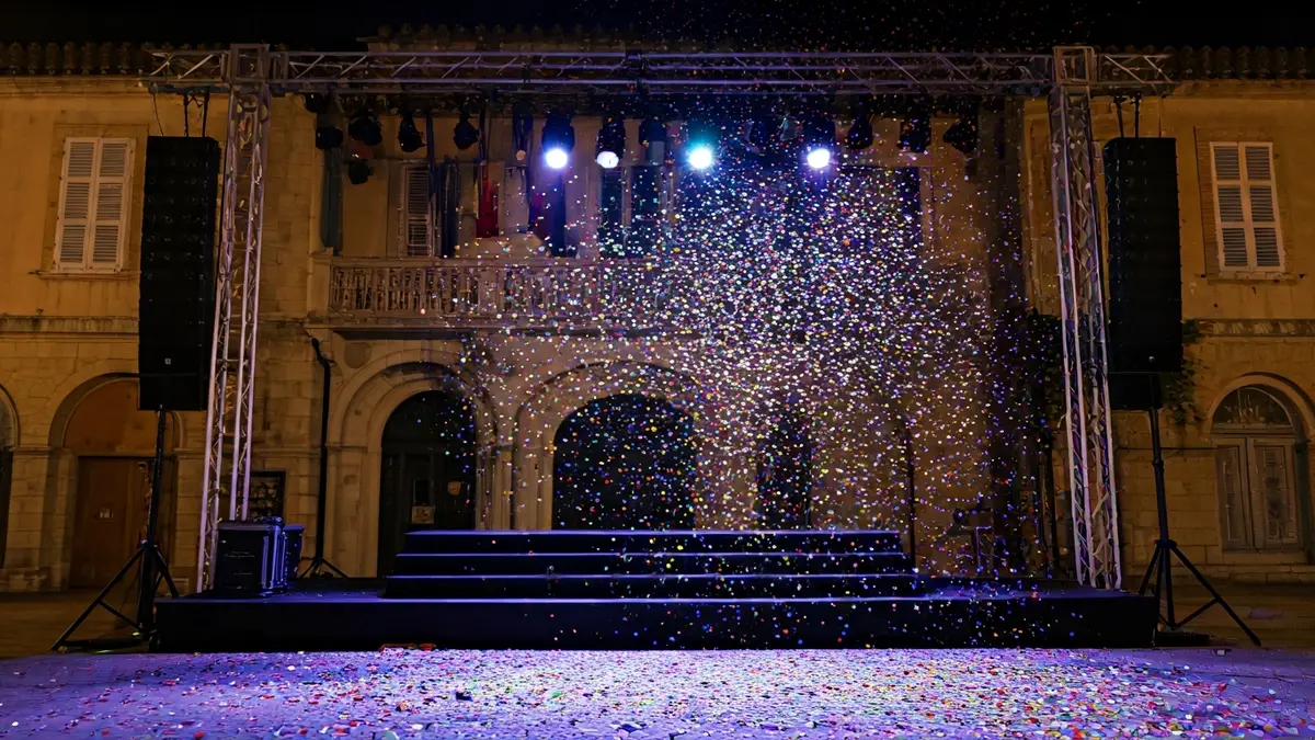 Imatge que suggerix una festa o celebració, amb confeti caent i un escenari buit, en un context de gestió municipal.