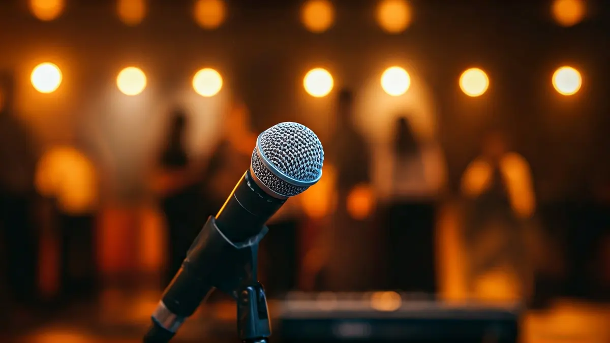 Imatge genèrica d'un micròfon en un escenari de club, amb instruments musicals desenfocats al fons.