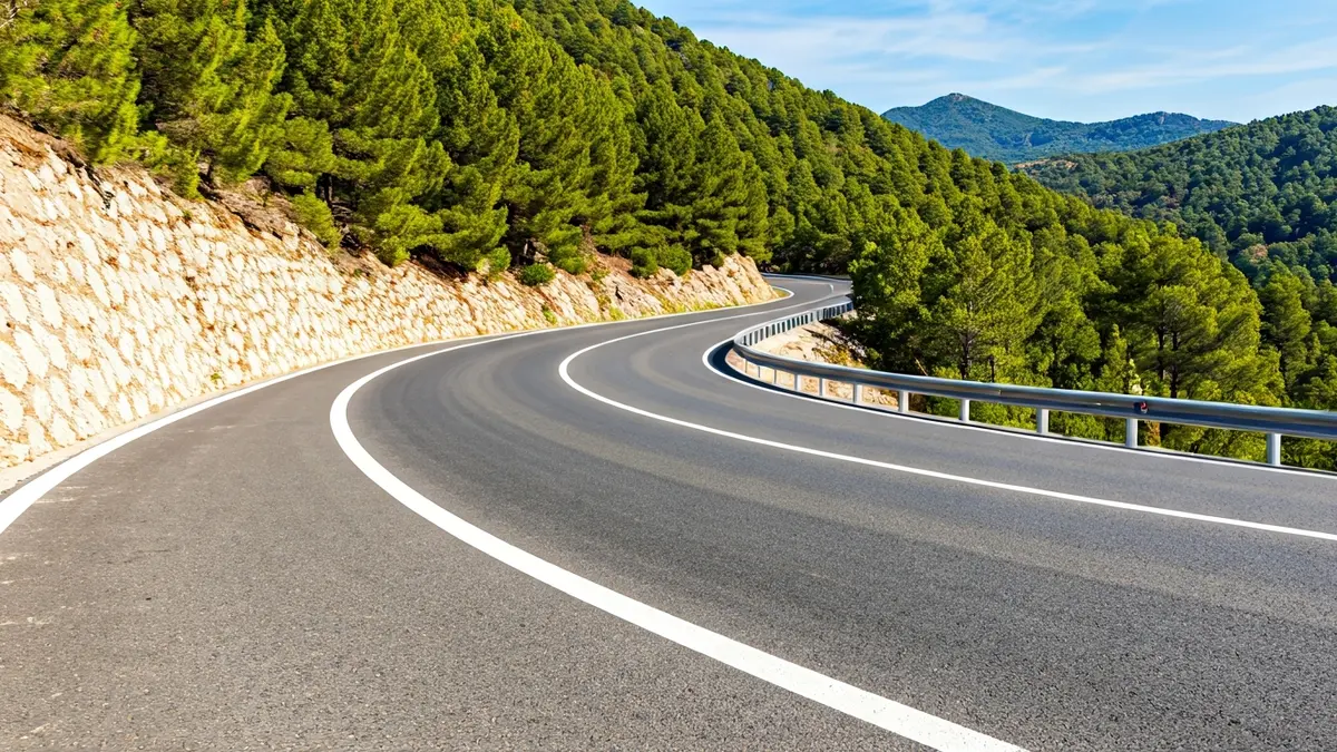 Imagen de una carretera de montaña con obras de mejora, ampliación de calzada y señalización.