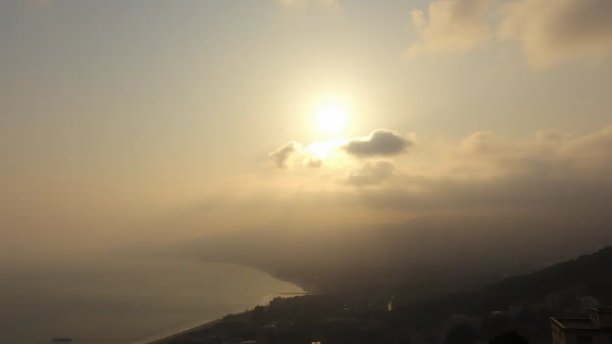 Imatge genèrica d'un matí assolellat en una ciutat costanera mediterrània, amb boira dissipant-se.