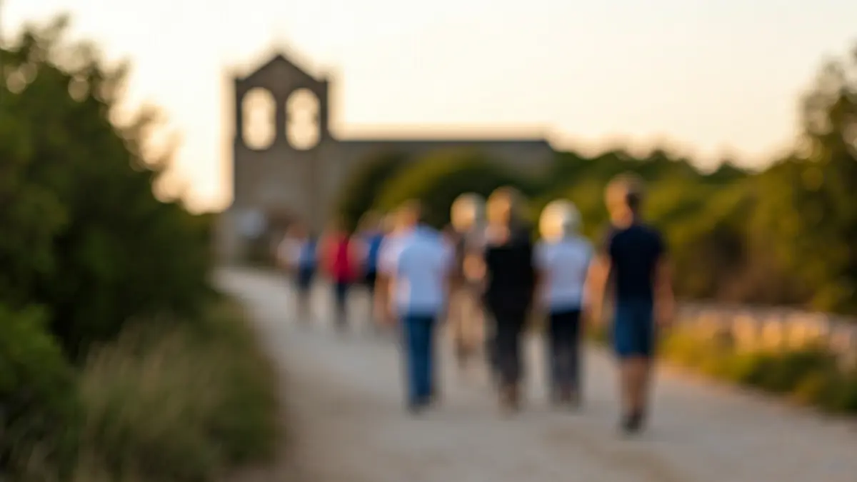 Imatge d'un grup de pelegrins caminant cap a una ermita al capvespre.
