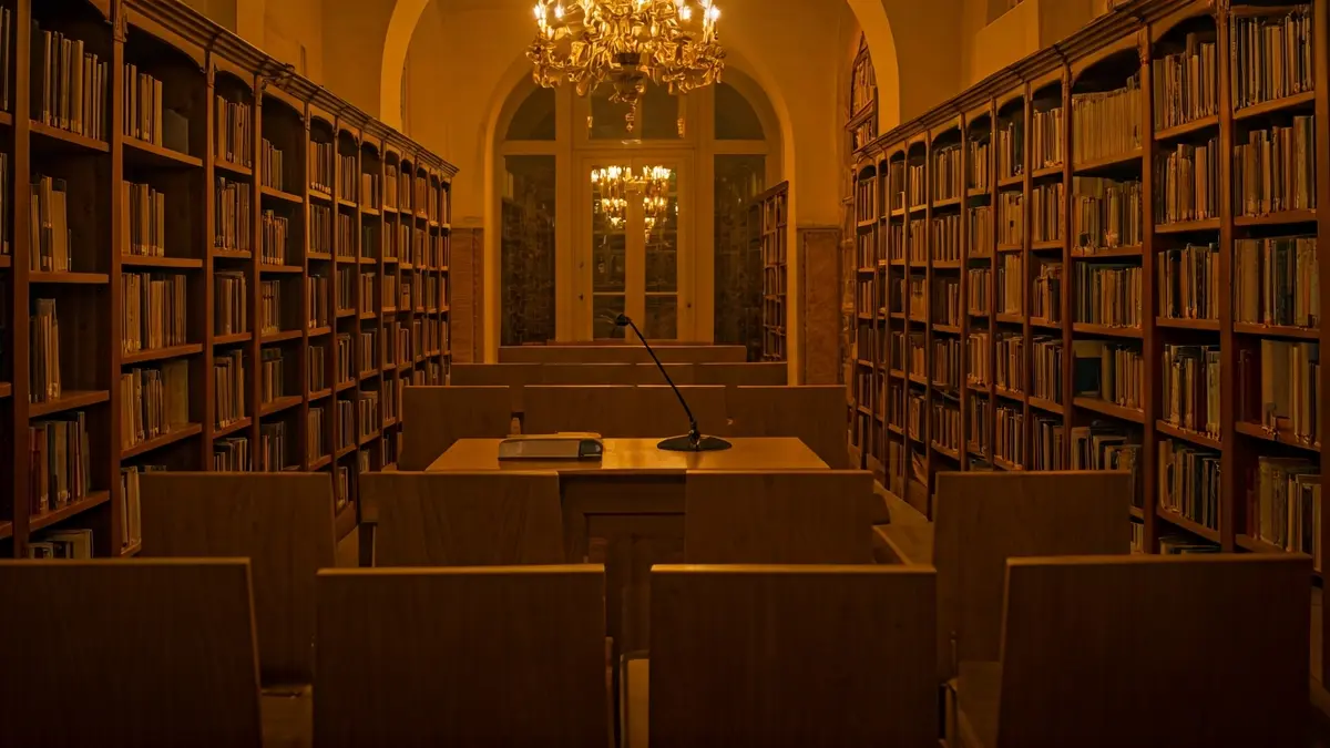 Imatge genèrica d'un interior de biblioteca amb un podi i micròfon, amb una atmosfera càlida de lectura.