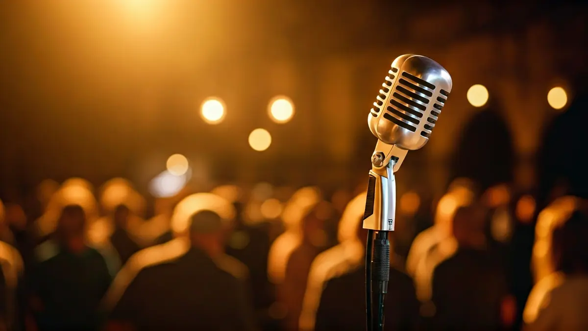 Imatge genèrica d'un micròfon en un escenari, amb instruments musicals desenfocats al fons i il·luminació càlida.