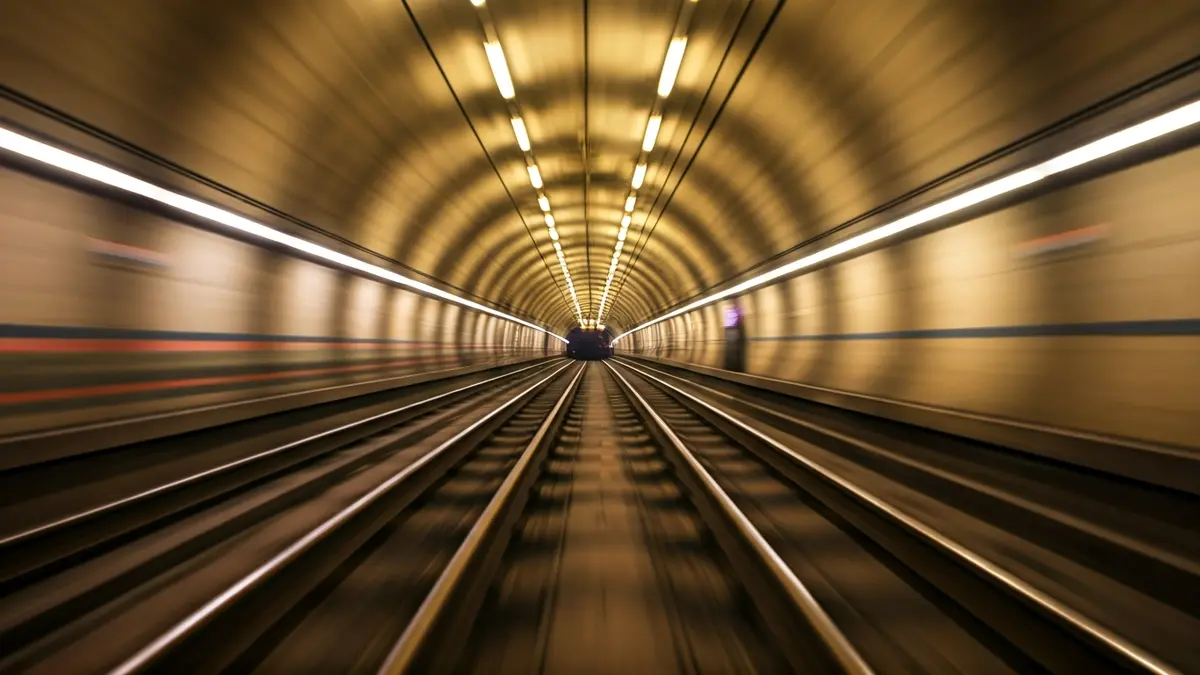 Imatge genèrica d'una via de metro en un túnel, amb llums borroses.