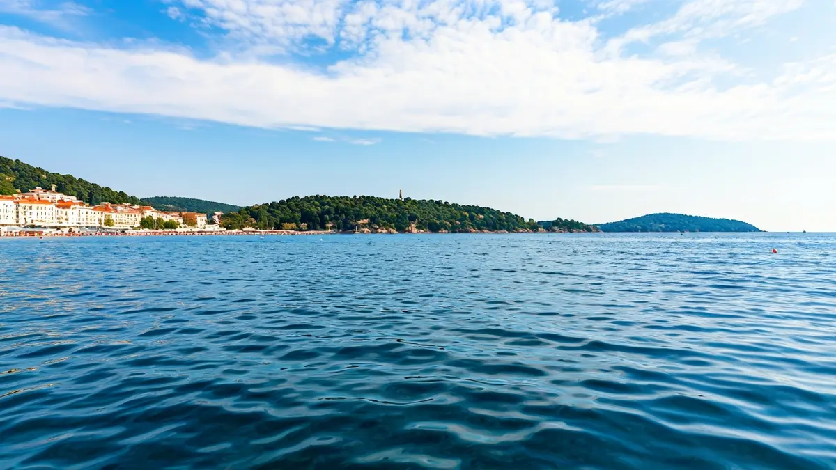 Generic image of a clean blue sea surface with a blurred coastline in the background.