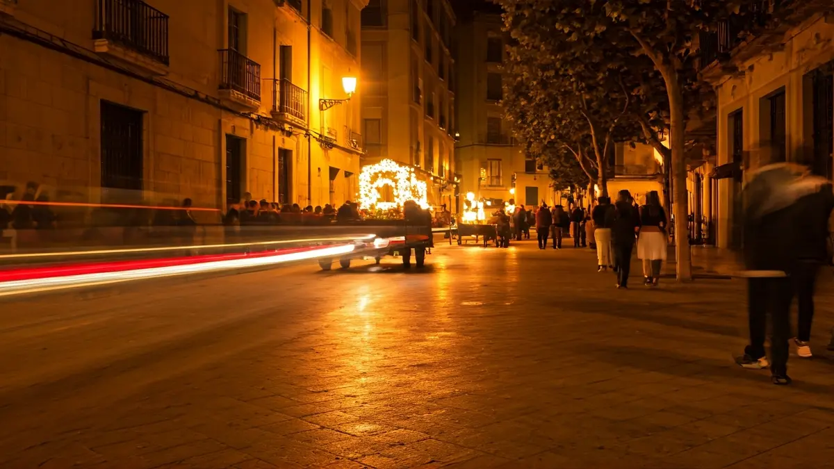 Imatge d'una cercavila nocturna amb carros engalanats i una foguera en una festa tradicional valenciana.