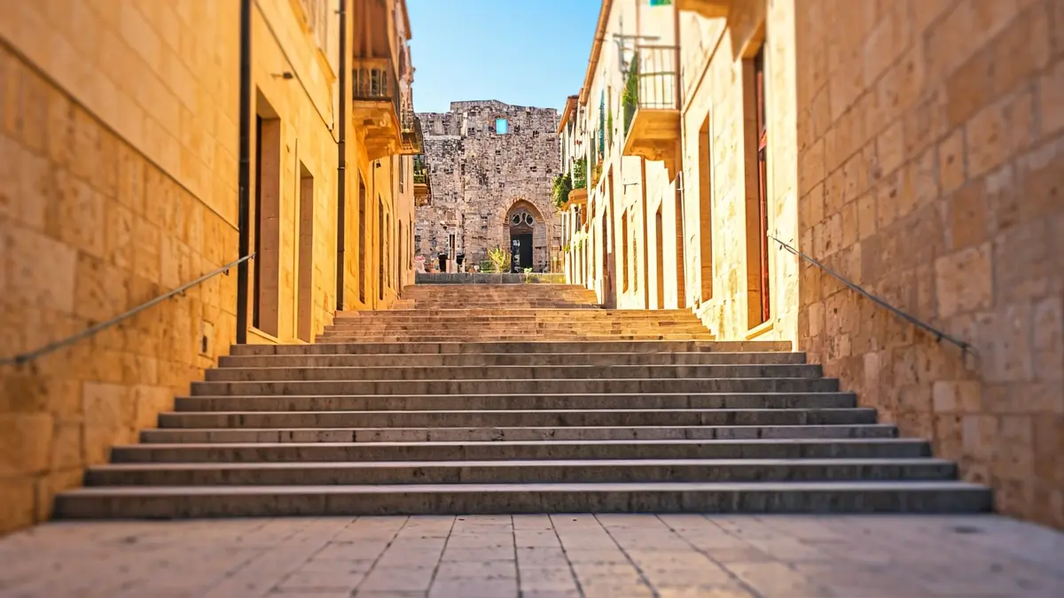 Image of stone pedestrian stairs in a historic neighborhood of Onda, with traditional buildings in the background.