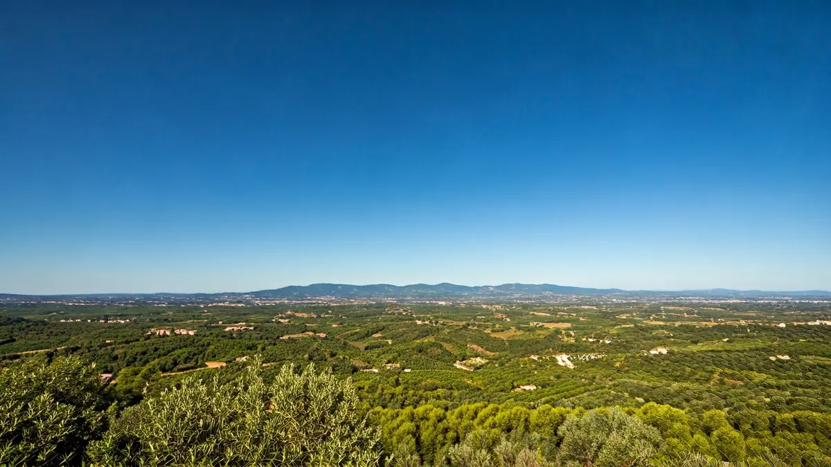 Generic image of a clear blue sky over a Mediterranean landscape, symbolizing stable and sunny weather.