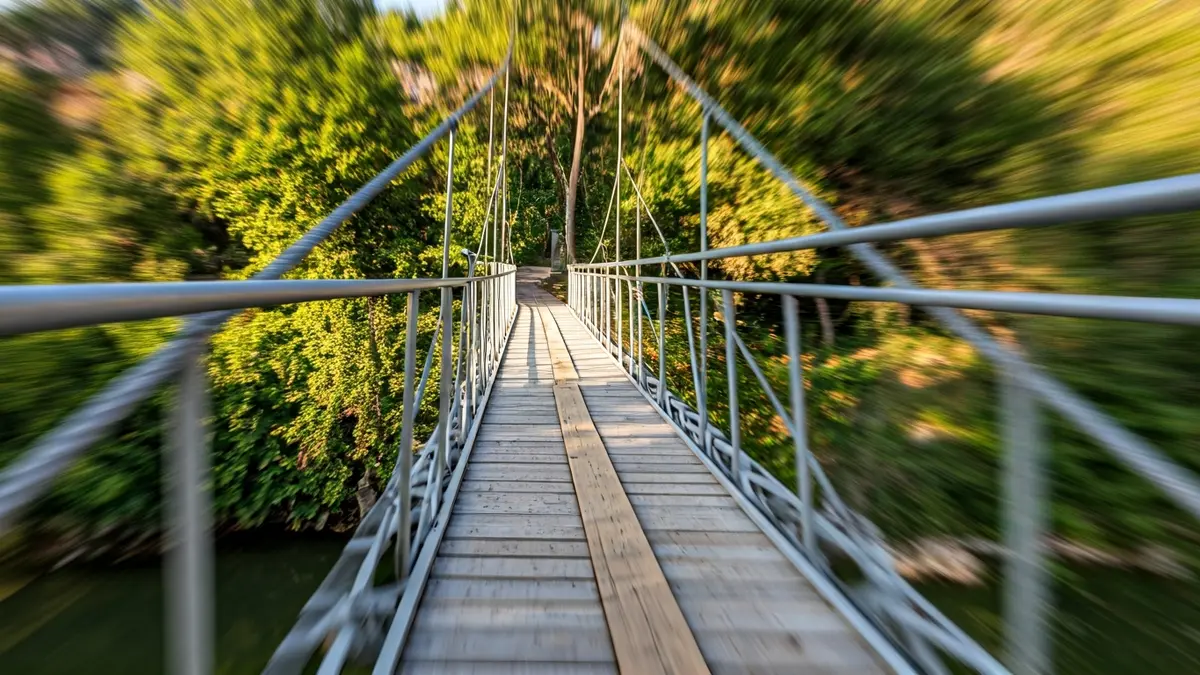 Imagen de una pasarela provisional sobre un río, con vegetación mediterránea en los márgenes.