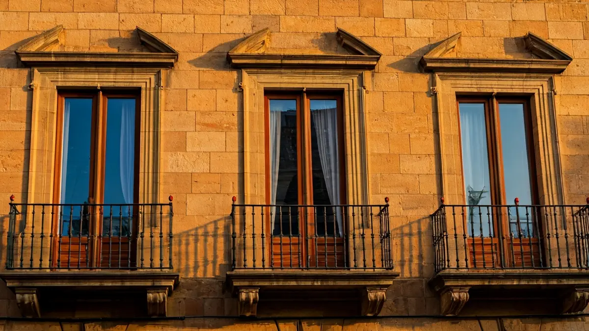 Façana de l'Ajuntament de Torrent amb balcons de ferro forjat sota la llum del sol.