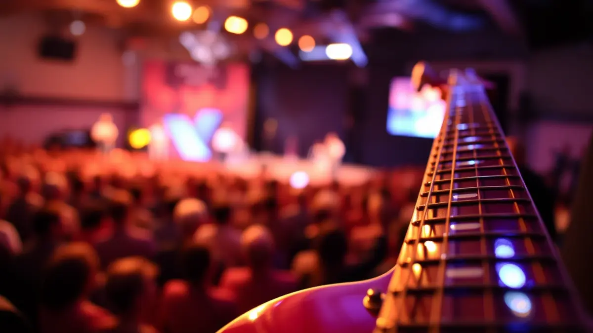 Imatge genèrica d'una guitarra en un escenari de concert, amb el públic desenfocat al fons.