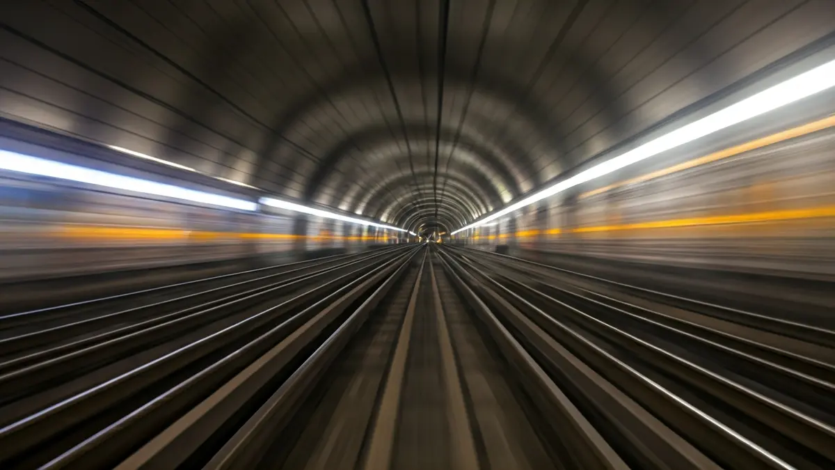 Generic image of a train track with blurred lights in the background, suggesting motion.