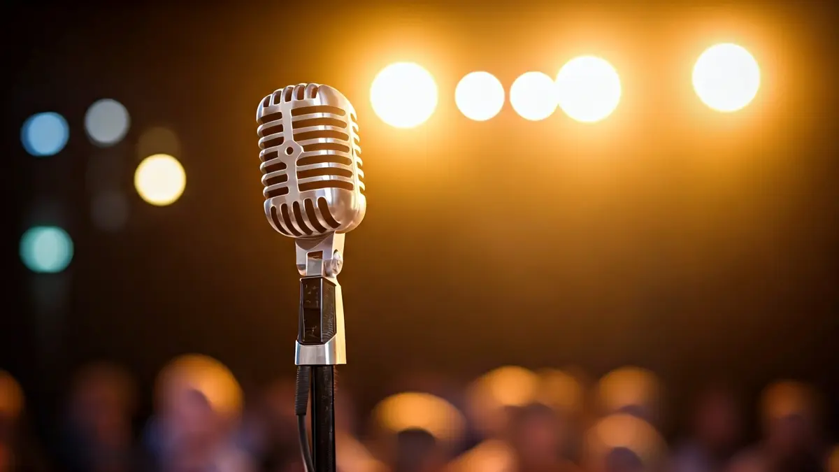 Imatge genèrica d'un micròfon antic en un escenari, amb focus desenfocats al fons.
