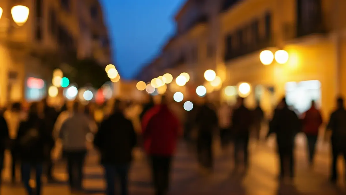 Imatge genèrica d'una multitud manifestant-se en un carrer mediterrani al capvespre.