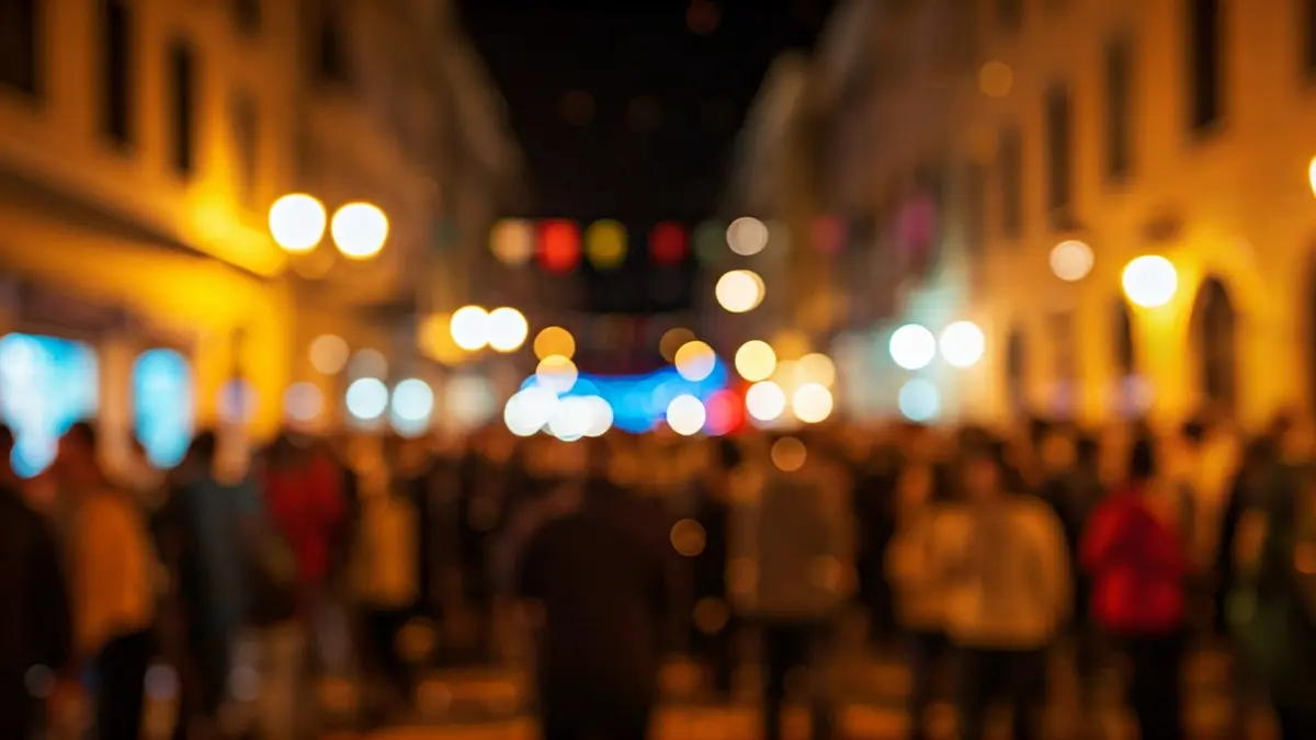 Generic image of a blurred crowd with confetti and vibrant lights in a Mediterranean street at night, capturing the festive atmosphere of a carnival.