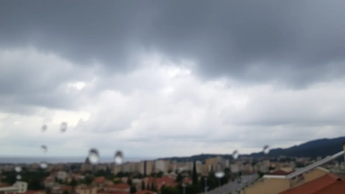 Imatge genèrica d'un cel ennuvolat amb gotes de pluja en un vidre, suggerint un oratge inestable.