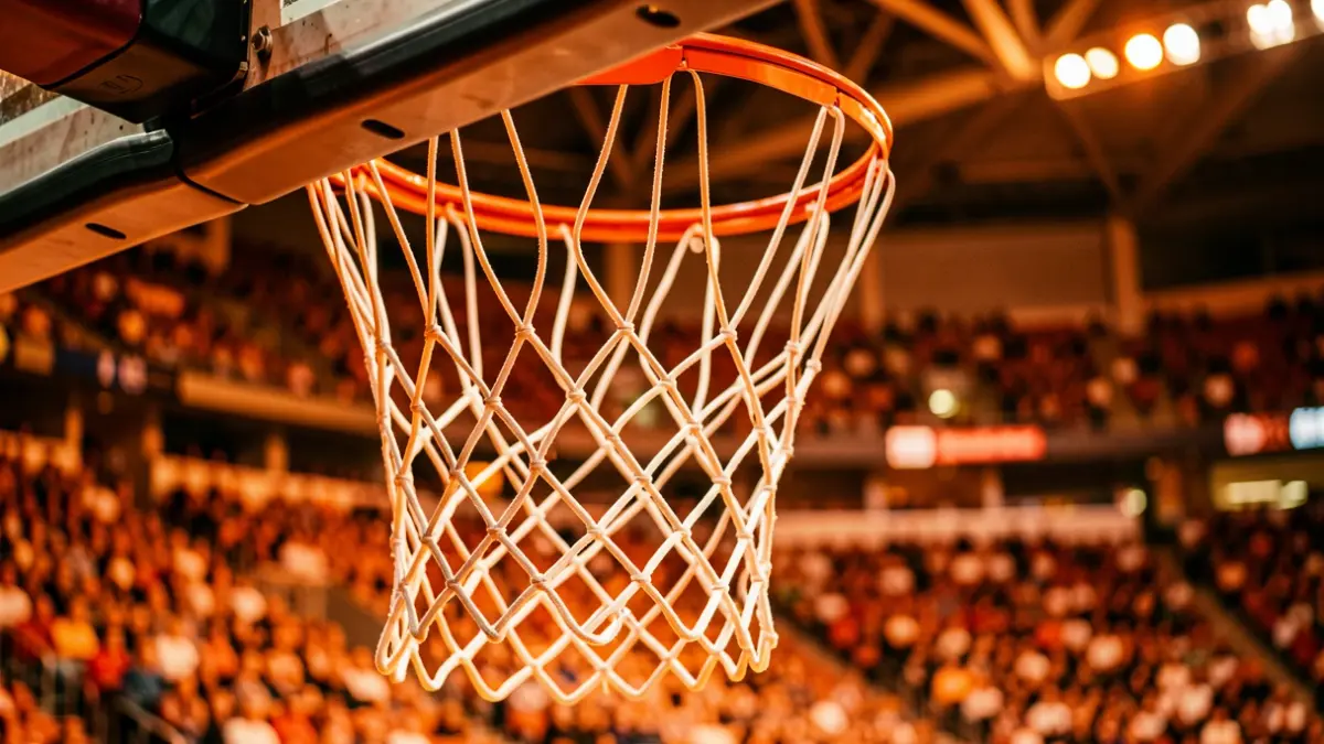 Image of a basketball hoop in a modern arena with the atmosphere of the stands blurred.
