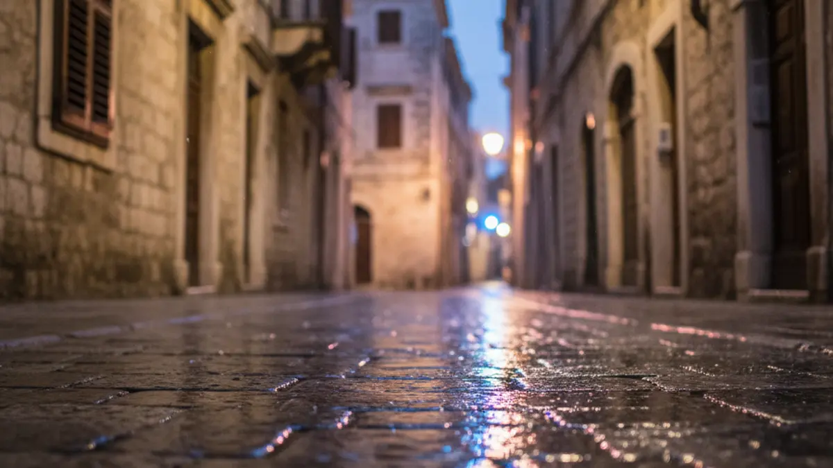Generic image of emergency lights reflecting on wet asphalt in a Mediterranean city.