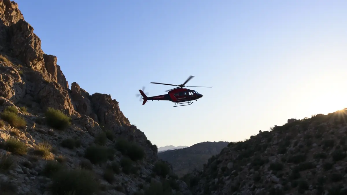 Imagen de un helicóptero de rescate sobrevolando un barranco rocoso en una zona mediterránea.