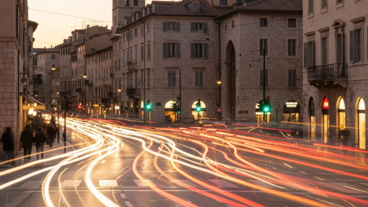 Imatge genèrica de trànsit urbà en una ciutat mediterrània al capvespre, amb llums de vehicles borroses.
