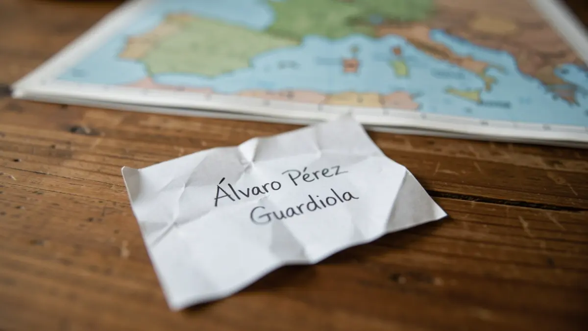 Imatge genèrica d'un nom escrit en un paper amb un mapa al fons.