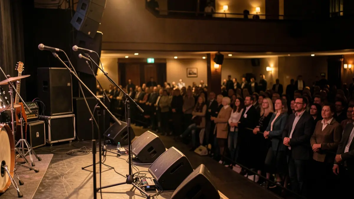 Imatge genèrica d'una sala de concerts amb un escenari i públic desenfocat.