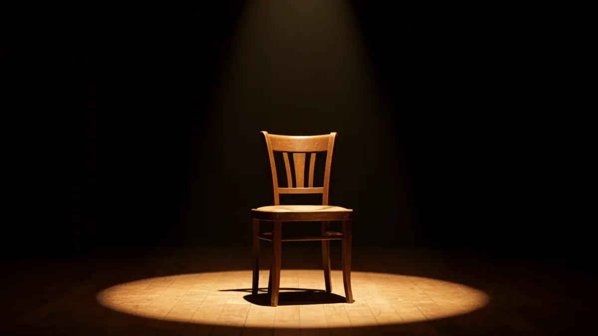 Imatge genèrica d'un escenari de teatre amb una cadira il·luminada per un focus.