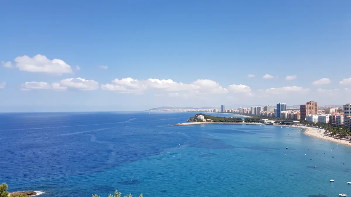 Imatge genèrica del cel i la costa de Benidorm amb sol i núvols dispersos.