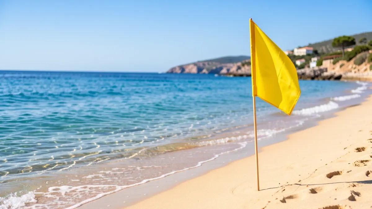 Generic image of a beach with a yellow flag and the Mediterranean Sea.