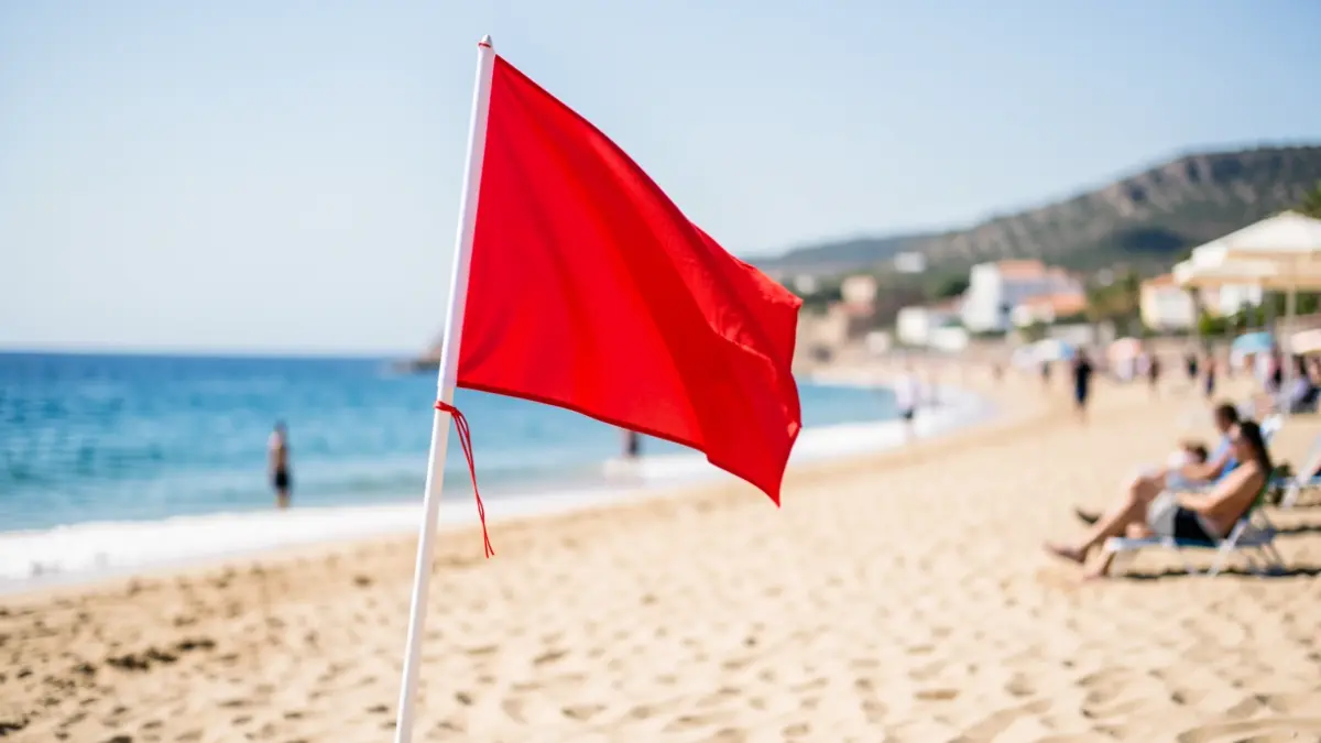 Red flag waving on La Roda beach in Altea to prohibit swimming.